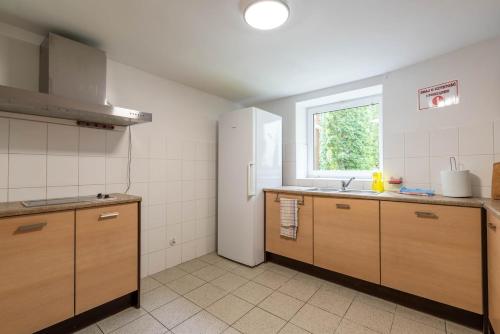 a kitchen with wooden cabinets and a window in it at Dom Pracy Twórczej in Świnoujście