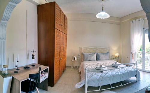 a bedroom with a bed and a desk and a table at Spacious Apartment in Mytilene in Mytilini