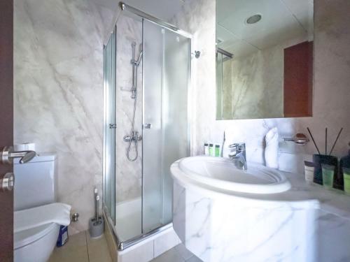 a bathroom with a shower and a sink and a toilet at Elite Estates - Both Sea & Marina View Princess Tower Unit in Dubai