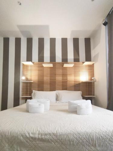 a bedroom with a large white bed with striped walls at Palermo Central B&B in Palermo