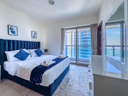 a bedroom with a large bed and a balcony at Elite Estates - Both Sea & Marina View Princess Tower Unit in Dubai