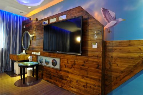 a room with a tv on a wooden wall at ZJ Motel in Hsinchu City