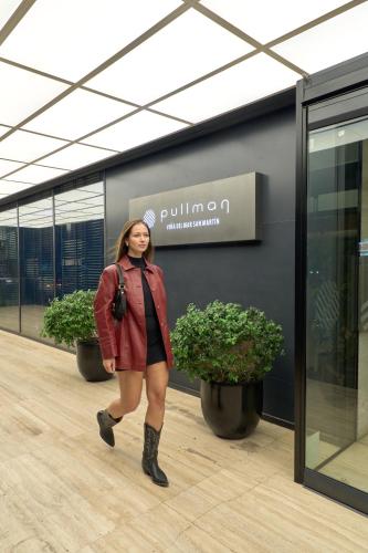 a woman is walking in a building at Pullman Vina del Mar San Martin in Viña del Mar