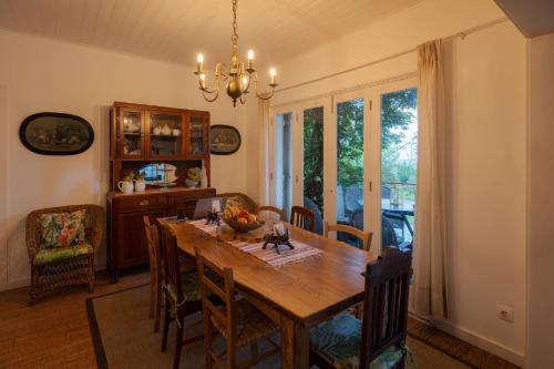 uma sala de jantar com uma mesa de madeira e cadeiras em Lake View House em Sete Cidades