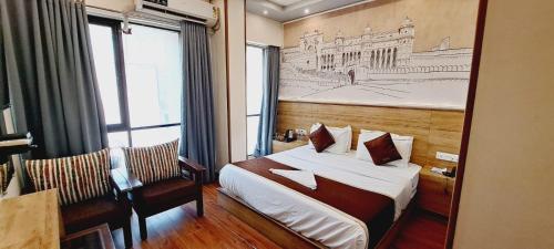 Hotel Freedom Star ReTreat في مومباي: غرفة في الفندق بسرير ورسم على الحائط