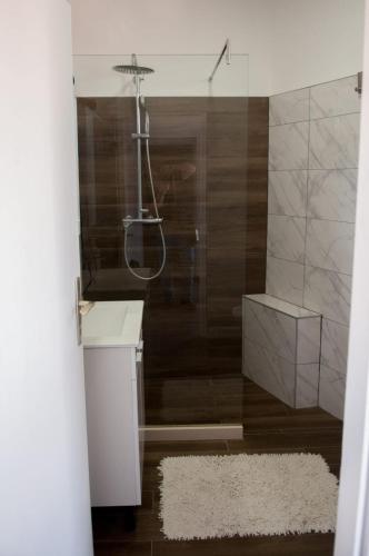 a bathroom with a shower and a white rug at GROTTA in Metković