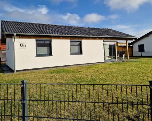a house with a fence in front of it at G11 Eingezäuntes Neubau-Haus in Eckwarderhörne in Großwürden