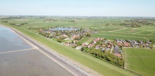 an aerial view of a village next to a body of water at G11 Eingezäuntes Neubau-Haus in Eckwarderhörne in Großwürden