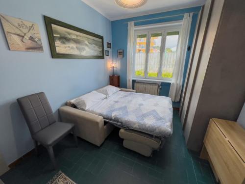 ein Schlafzimmer mit einem Bett, einem Stuhl und einem Fenster in der Unterkunft Casa Carlotta in San Bartolomeo al Mare