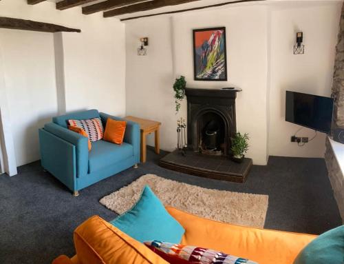 a living room with a blue couch and a fireplace at Leven's Rest - 2 Bed Maisonette in Backbarrow