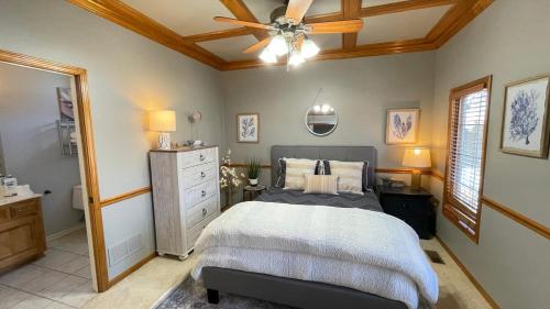 1 dormitorio con 1 cama y ventilador de techo en Beautiful relaxing private villa next to a pond smart home and Traeger Grill en Overland Park