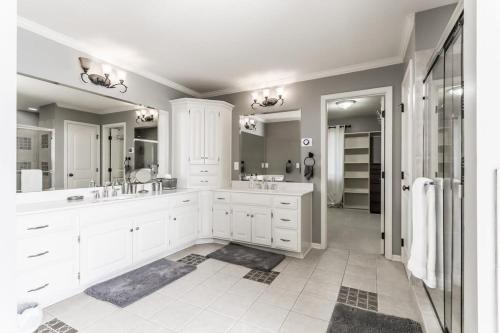 a white bathroom with two sinks and a mirror at Beautiful relaxing private villa next to a pond smart home and Traeger Grill in Overland Park