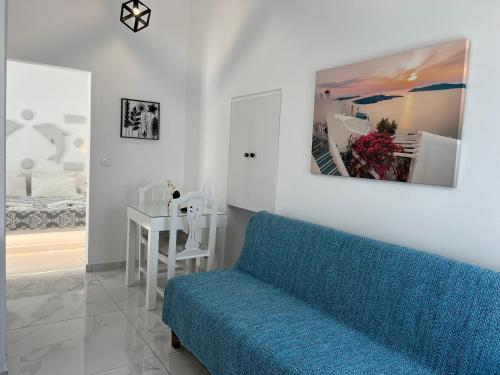 a living room with a blue couch and a bedroom at Villa Pavlina in Karterados