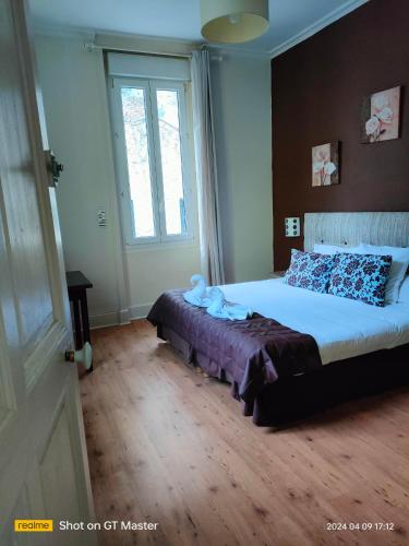 a bedroom with a bed and a large window at Auberge Du Parc in Orgon