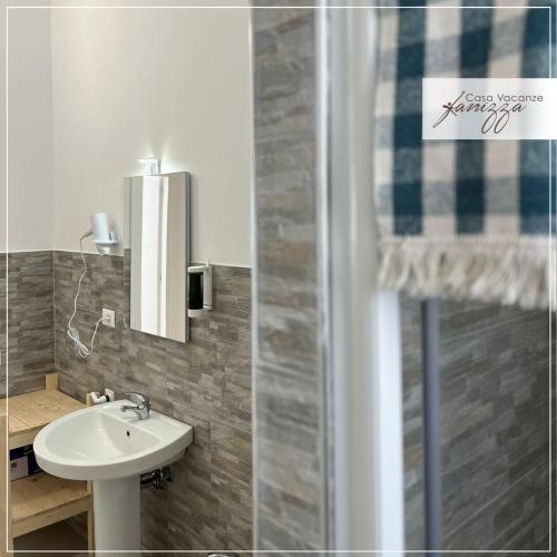 een badkamer met een wastafel en een spiegel bij Fanizza apartment 16 in Alberobello