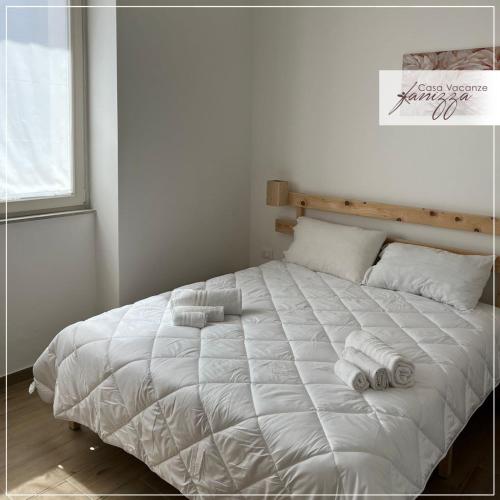 een slaapkamer met een wit bed en handdoeken bij Fanizza apartment 16 in Alberobello