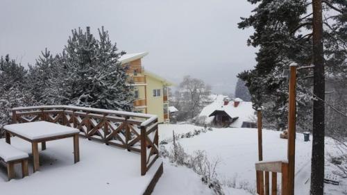 einen schneebedeckten Hof mit zwei Bänken und einem Haus in der Unterkunft Villa Albatros in Ober-Dellach