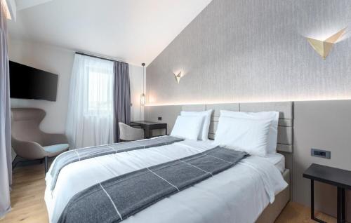 ein Hotelzimmer mit einem großen Bett mit weißer Bettwäsche in der Unterkunft Ferienhaus in Nova Vas mit Terrasse, Garten und Grill in Brtonigla