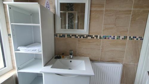 a bathroom with a white sink and a mirror at Highfield House! in Wellingborough