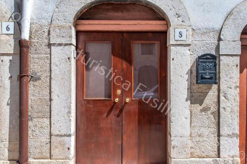 een houten deur in een stenen gebouw met het nummer zes bij Ferienwohnung für 5 Personen ca 90 qm in Andria, Adriaküste Italien Ostküste von Apulien in Andria