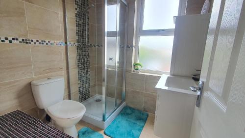 a bathroom with a toilet and a glass shower at Highfield House! in Wellingborough