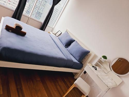 1 dormitorio con cama con sábanas azules y ventana en Vortex suites klcc by Rahat, en Kuala Lumpur