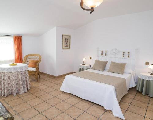 a bedroom with a white bed and two tables at El Nogal De Nieva in Nieva