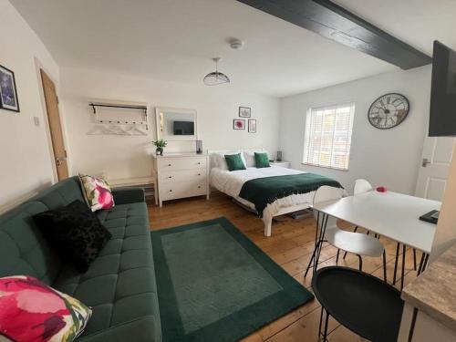1 dormitorio con cama, sofá y mesa en The Boardroom, en Hathern