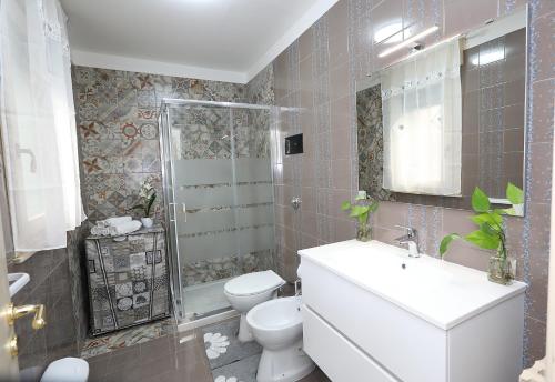a bathroom with a toilet and a sink and a shower at Casa in centro Ragusa con parcheggio privato in Ragusa