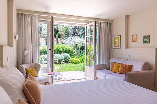 a hotel room with a bed and a balcony at La Villa du Moulleau in Arcachon