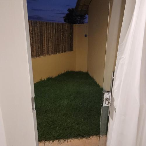 サン・フェリックス・ド・トカンティンスにあるPousada Angatu Jalapãoの緑の芝生のある部屋への開口ドア