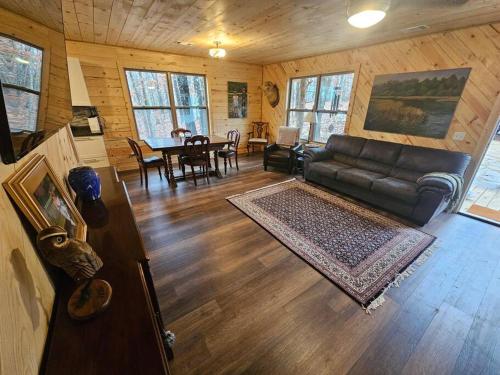 ein Wohnzimmer mit einem Sofa und einem Tisch in der Unterkunft Hideaway Cabin near Mammoth Springs, Ark in Mammoth Spring