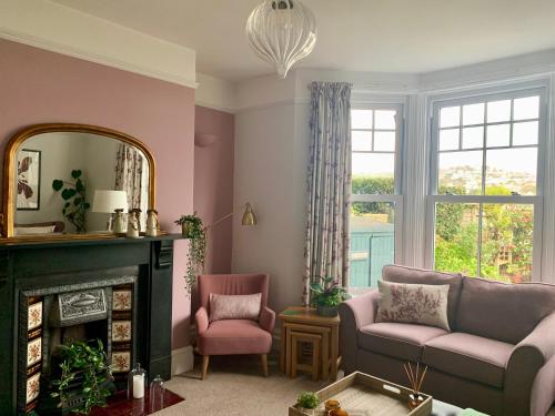 a living room with a fireplace and a mirror at A unique and spacious river front property in Shaldon