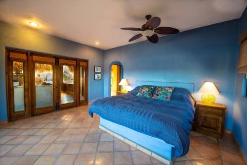 1 dormitorio azul con 1 cama y ventilador de techo en Casa de Vista Hermosa, en Loreto
