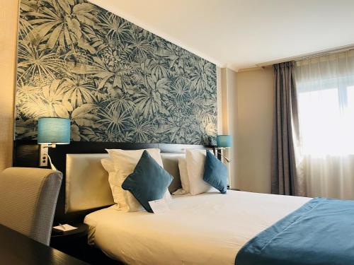 Habitación de hotel con cama y mural en la pared en Best Western Allegro Nation, en París