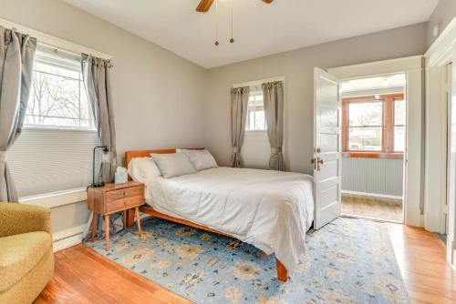 a bedroom with a bed and a chair and windows at Cozy Anna Home Near Southern Illinois Attractions! in Anna