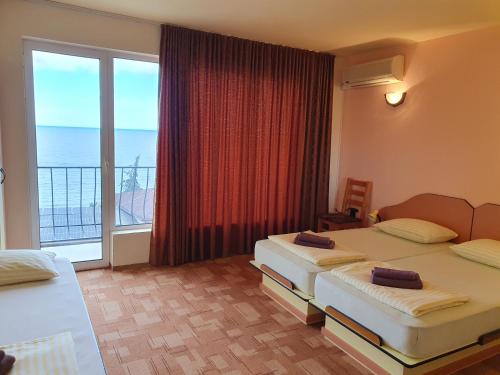 um quarto de hotel com duas camas e uma grande janela em Family Hotel Pier em Golden Sands