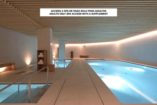サン・セバスティアンにあるHotel Arima & Spa - Small Luxury Hotelsの上の看板のある建物内のスイミングプール