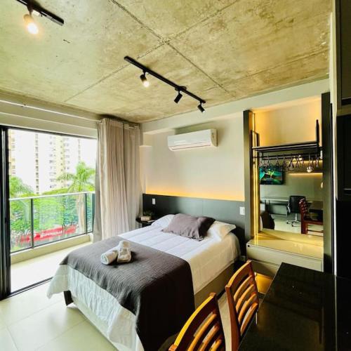 - une chambre avec un lit et une grande fenêtre dans l'établissement Studio em Maringá, à Maringá