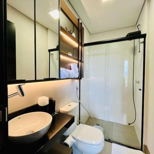 La salle de bains est pourvue de toilettes, d'un lavabo et d'une douche. dans l'établissement Studio em Maringá, à Maringá