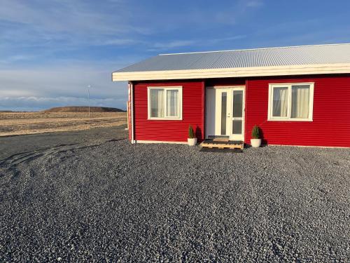 een rood huis in het midden van een veld bij Nadia's Country View Home in Selfoss