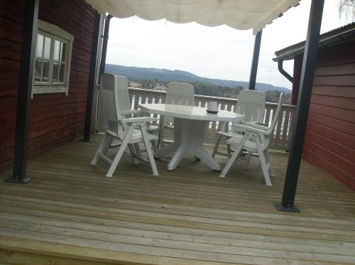 una mesa blanca y sillas en un porche en Täljelantgårdshotell en Tälje