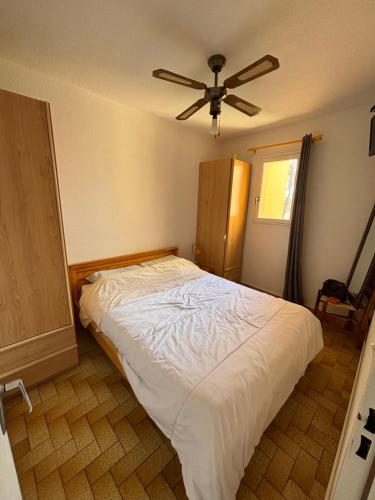 a bedroom with a bed with a ceiling fan at Appartement T2 tout équipé in Port Leucate
