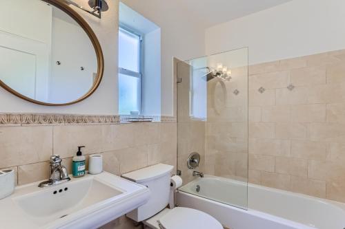 een badkamer met een toilet, een wastafel en een spiegel bij The Glenn House Vacation Home - New in West Palm Beach