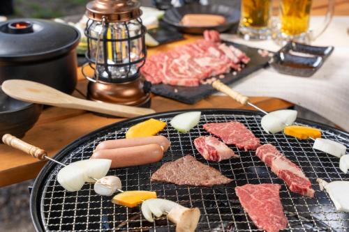 a grill with meats and vegetables on a table at Glamchette Okayama -Glamping & Auto Camp- - Vacation STAY 19606v in Mimasaka