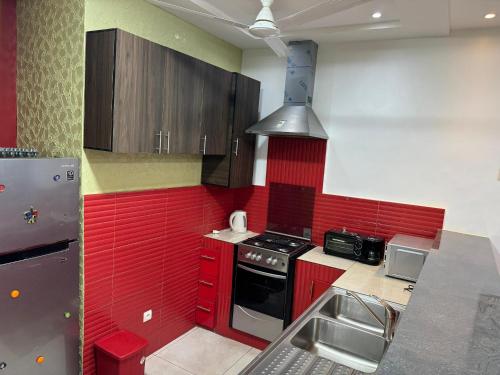 a kitchen with red cabinets and a stove top oven at Chic House in Abomey-Calavi