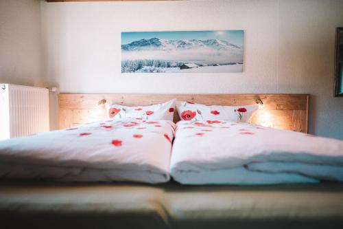 um quarto com duas camas com flores vermelhas em Ferienwohnung Lechtal mit 2 Schlafzimmer und großem Balkon em Bach