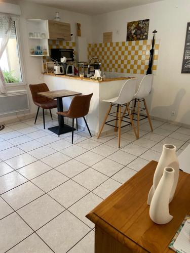 een keuken met een tafel en stoelen en een aanrecht bij Meuble maison vigneronne in Saint-André-de-Sangonis