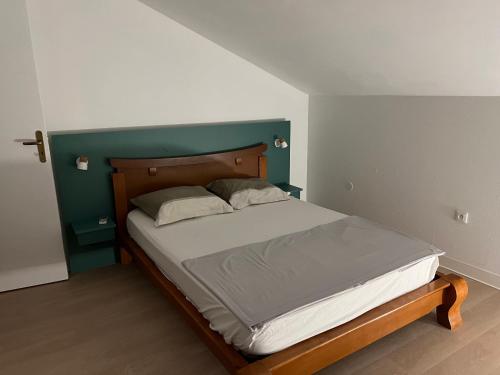 - un lit avec une tête de lit en bois dans une chambre dans l'établissement GITE PEI LA VANILLE "Studio Duplex TI Kaz", à Sainte-Suzanne