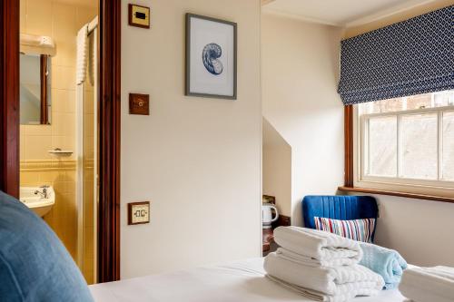 ein Schlafzimmer mit einem Bett und einem blauen Stuhl in der Unterkunft The Old Townhouse - Room 4 in Poole